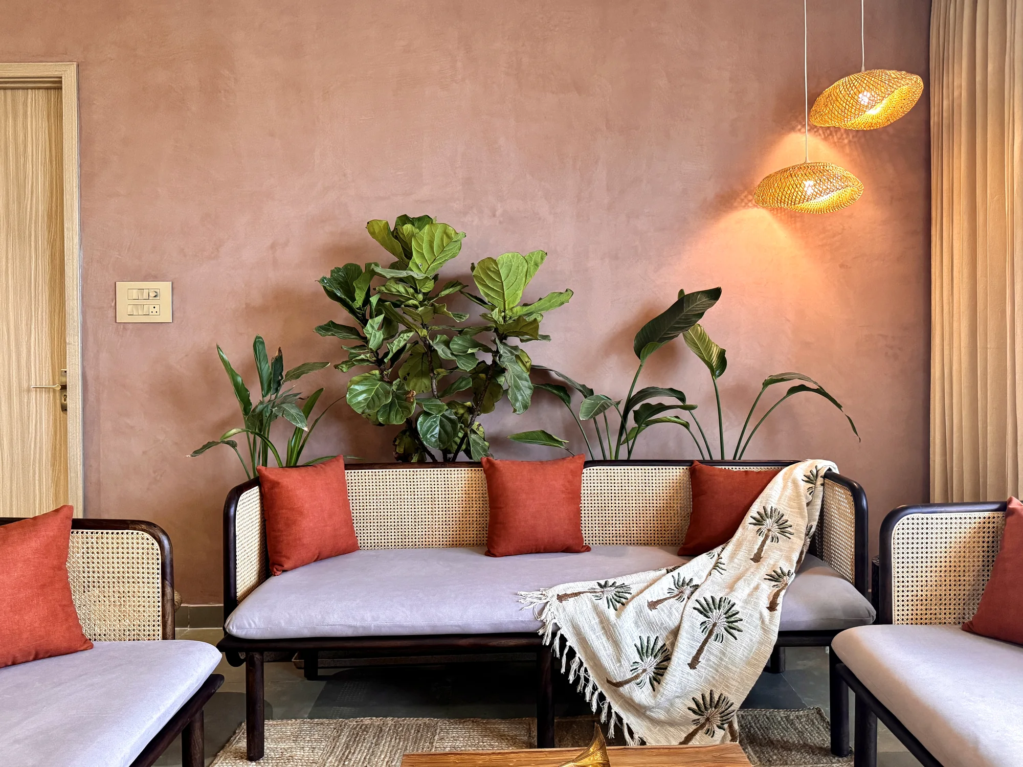Living room seating arranged with indoor plants, soft textures and warm ambient lighting